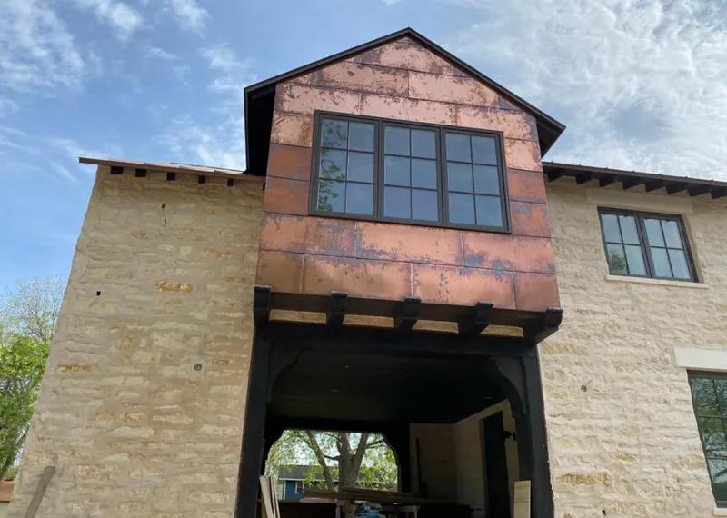 Copper metal panel facade on a stone building for Skylight Installation in DeForest